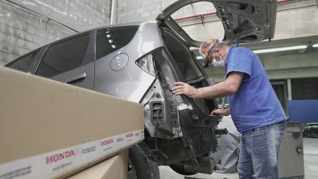 Técnico fazendo a troca do parachoque traseiro de um Honda Fit